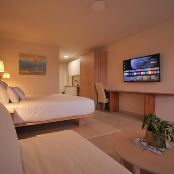 Double bed with a television on the wall inside the apartment