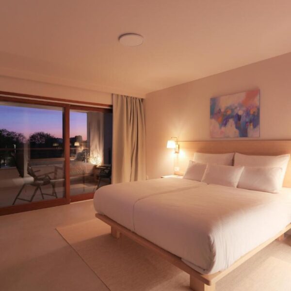 Double bed with night lights and painting by spacious patio door