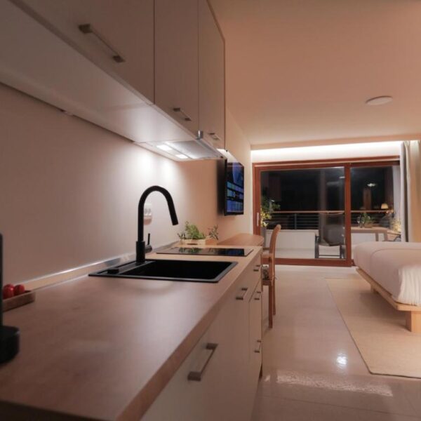 View of the apartment bed and patio from the kitchen