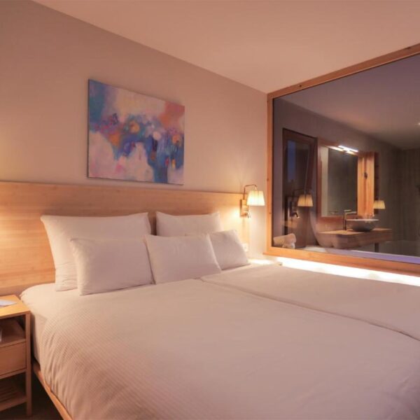 View of the double bed with mirror window to whirlpool bath