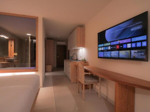 View of white coloured kitchen and big smart tv