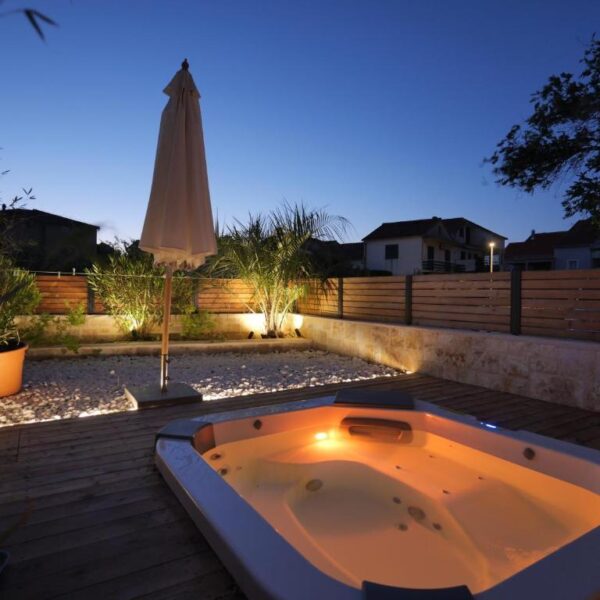 Evening view of jacuzzi, palms and flush nature