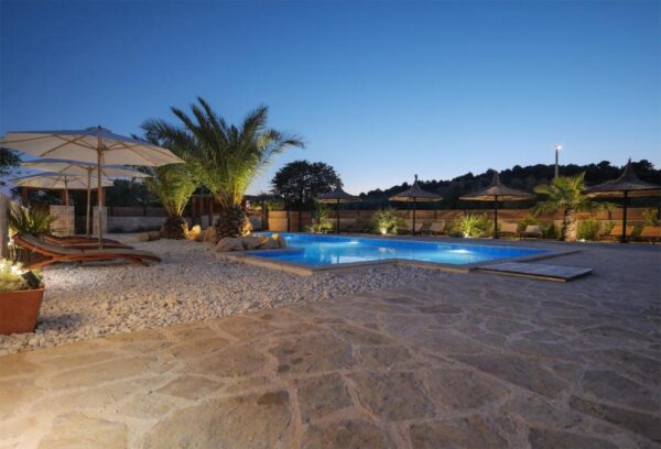 Eveningview of pool, palms and terrace