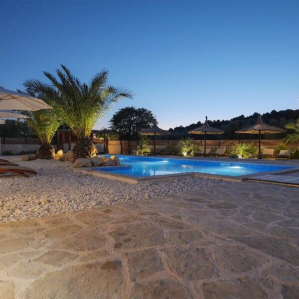 Eveningview of pool, palms and terrace