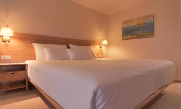 Premium studio apartment during nighttime, double bed with white sheets and pillows