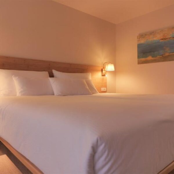 Premium studio apartment during nighttime, double bed with white sheets and pillows