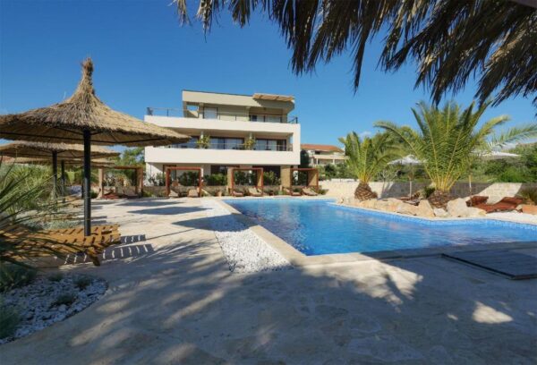 View of villa Lojena from the entrance, view of villa, pool, palms and surrounding nature